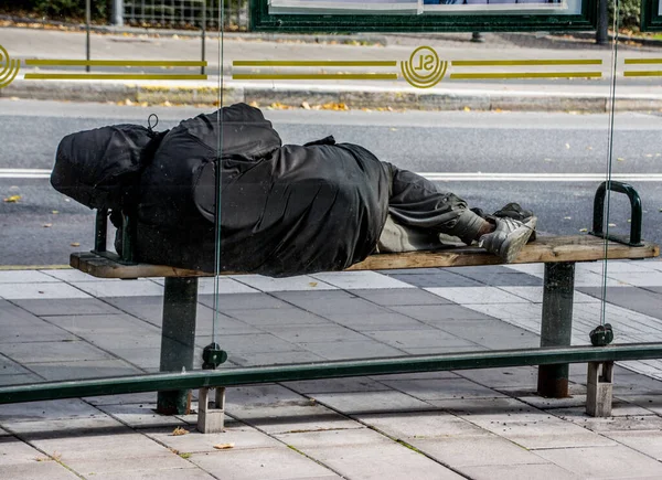 スウェーデンのストックホルム中心部のバス停のベンチにホームレスが横たわっていたと推定 — ストック写真