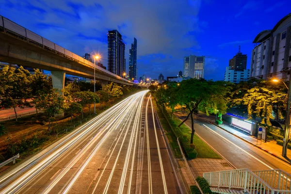 Putující světlo rozostření dopravy ve městě — Stock fotografie