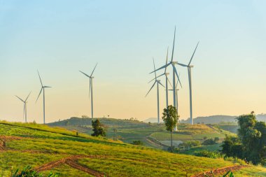 Rüzgar türbinleri günbatımında rüzgardan elektrik üretmek için park ederler.