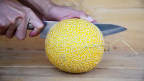 那个人用刀把黄色的甜瓜劈开放在木板上 — 图库视频影像