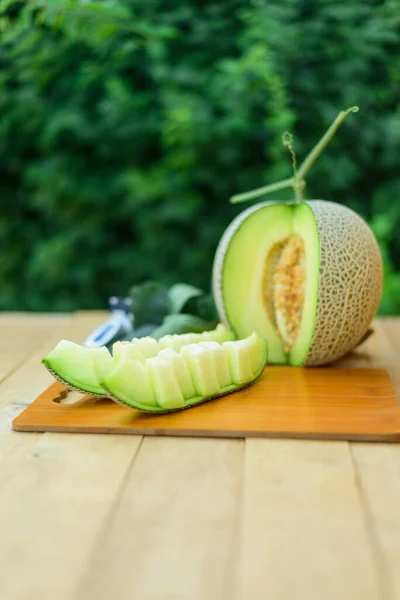 Closeup to sweet Fresh green melon on wood plate