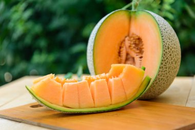 Portakal karpuzunu ahşap tabakta ikiye ayır.