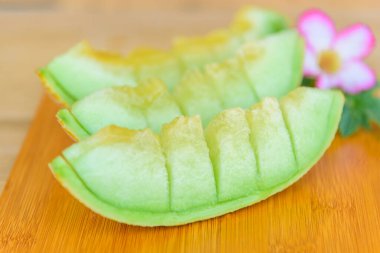 Yakından bakınca ahşap tabakta tatlı yeşil karpuzu bölmek için odaklan.