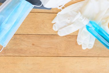 Eli temizlemek için dezenfektan jeli ve arka planda tıbbi lastik eldivenler.