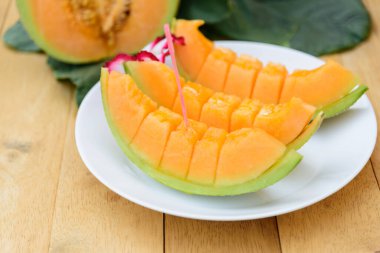 Tabakta bir sürü taze portakal karpuzu var.