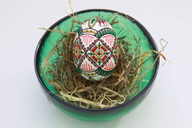 Geleneksel el yapımı Paskalya yumurtaları samanlıkta cam kasede. Romanya 'nın Bucovina kentindeki el mumu boyama tekniği Moldova ve Doğu Avrupa' da Paskalya yumurtalarını süslemek için kullanıldı