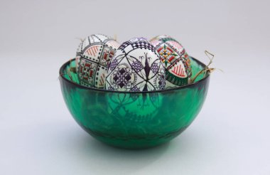 Geleneksel el yapımı Paskalya yumurtaları samanlıkta cam kasede. Romanya 'nın Bucovina kentindeki el mumu boyama tekniği Moldova ve Doğu Avrupa' da Paskalya yumurtalarını süslemek için kullanıldı