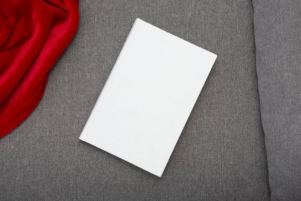 Book with blank cover and empty cover on a gray sofa