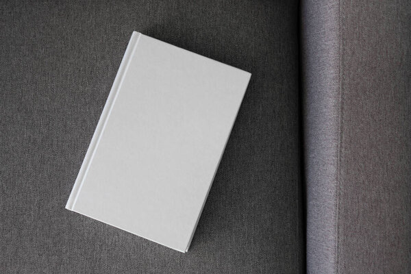 Книга с бланковой обложкой и пустой обложкой на диване