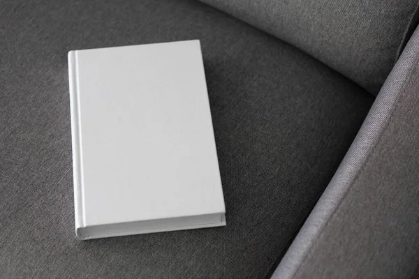 Book with blank cover and empty cover on a gray sofa