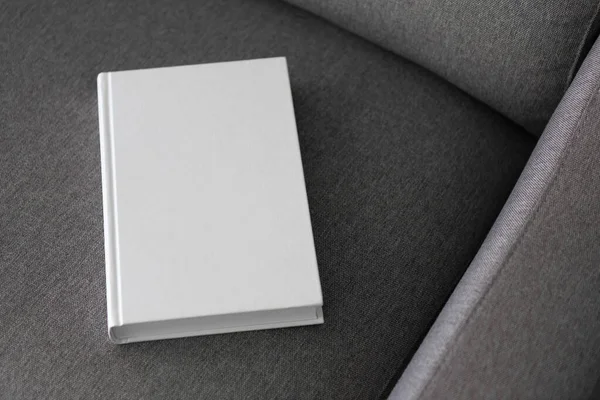 Boş kapaklı bir kitap ve gri bir kanepede boş bir kapak.