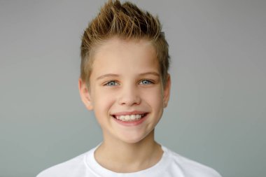 Çocuk gülümser ve sivri dişlerini gösterir. Diş hekimliği ve sağlık hizmetleri