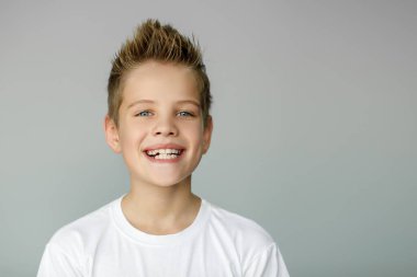 Çocuk gülümser ve sivri dişlerini gösterir. Diş hekimliği ve sağlık hizmetleri
