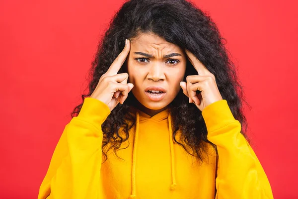 Nervous african woman breathing calming down relieving headache or managing stress, black girl feeling stressed massaging temples exhaling isolated on red background.