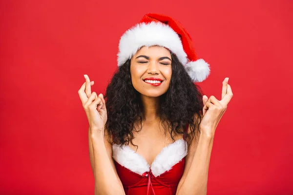 サンタクロースの服で美しい笑顔幸せなアフリカ系アメリカ人の黒人女性は 赤の背景に隔離された 新年とクリスマスのコンセプト — ストック写真
