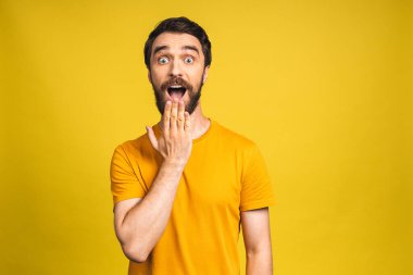 Mutlu galip! Şok olmuş genç bir erkeğin portresi ağzını açık tutar, şaşırır ve büyük bir şaşkınlık yaratır. Pembe sarı arkaplanda izole edilmiş..