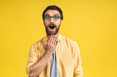 Mutlu galip! Şok olmuş genç bir erkeğin portresi ağzını açık tutar, şaşırır ve büyük bir şaşkınlık yaratır. Pembe sarı arkaplanda izole edilmiş..