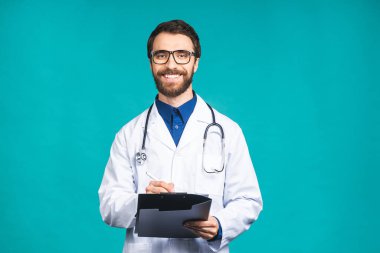 Mutlu gülümseyen sakallı doktor mavi arka planda izole bir şekilde panoya yemek tarifi yazıyor..