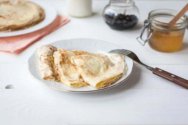 Frukost med pannkakor, sylt, honung och mjölk — Stockfoto