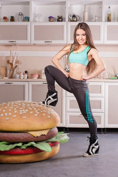 Healthy girl fighting against hamburger — Stock Photo, Image