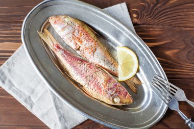 Fried red mullet on the oval dish clipart