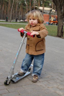 Parkta motosikletli küçük bir çocuk yürüyüşe çıktı.