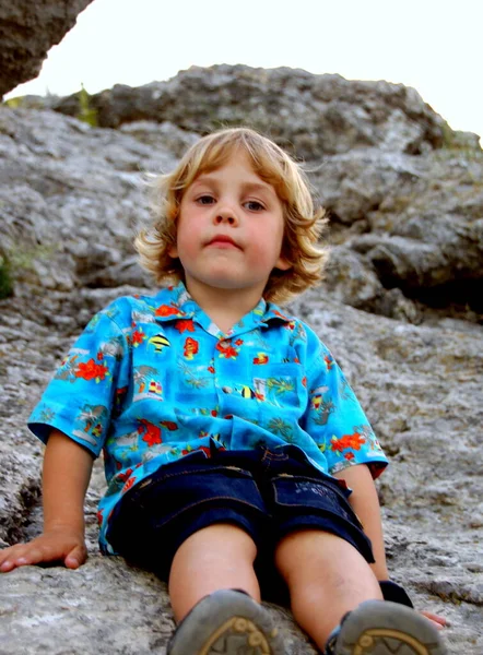 Ritratto Bambino Con Capelli Biondi Camicia Luminosa Seduto Una Roccia — Foto Stock