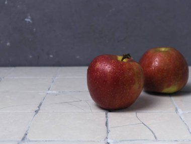 Döşeme arkaplanında damla olan kırmızı elmalar, yaratıcı arkaplan, kopyalama alanı