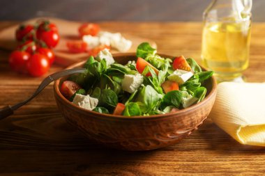 Marul yaprağından salata fasulye, peynir, kiraz domatesleri, ahşap bir tahtanın üzerinde seramik bir kasede. (Valerianella Locusta) Diyet, sağlıklı gıda ve vejetaryenlik kavramı. Yumuşak odaklanma. Vogerlsalat. keto diyeti 