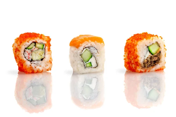 Set of three sushi rolls on a white background with reflection. Sushi roll with rice, tofu cheese, flying fish roe, crab meat and avocado, salmon. Sushi menu. Japanese and Asian cuisine, restaurant.