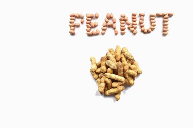 Bir avuç soyulmamış fıstık ve beyaz arka planda katlanmış 