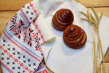 Beyaz bir havlunun üzerinde bembeyaz bir havluyla buğday ekmeği ve dikenleri..