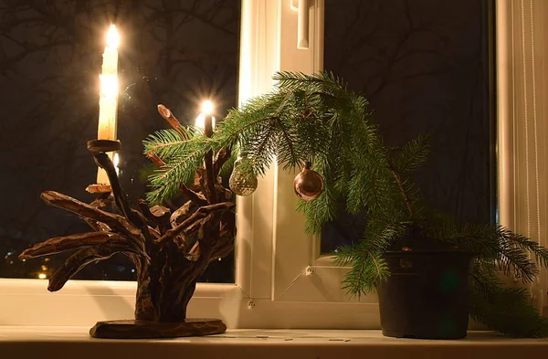 촛불이 촛대와 크리스마스 트리의 가지가 창턱에 촛불이 촛대가 있는데 촛대는 — 스톡 사진