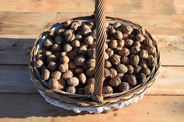 Tahta bir masada ceviz dolu sepet, üst manzara..