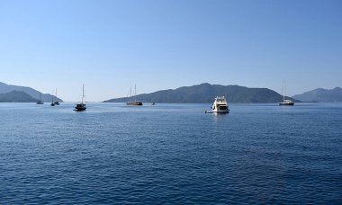 Körfezin girişindeki yol kenarında birkaç küçük gemi var..