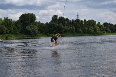 Bir adam nehirde wakeboard sürmeyi öğreniyor..