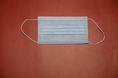 Kırmızı grunge arka planda koruyucu yüz maskesi. Alerjinin korunması, koronavirüs, grip ve diğer hastalıklar ve virüs enfeksiyonları. Boşluk resmini kopyala.