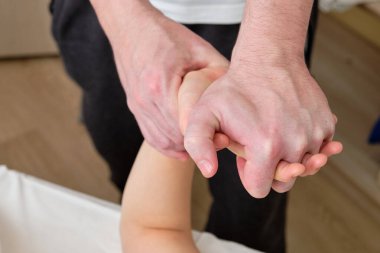 Üniforma giymiş bir masör müşterisine el ve parmak masajı yapıyor. Sıhhatli masaj ve vücut gevşeme sekansı. Sağlık ve İlaç kavramı. 