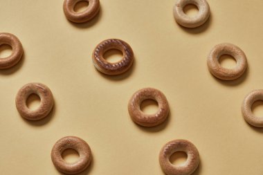 Sarı yüzeydeki Sushki deseninin üst görüntüsü. Rus ve Ukrayna mutfağından yemekler, hamur şeklinde katı halka şeklinde ürünler, koyun eti ürünleri. Slavlar arasında en yaygın çay atıştırmalıklarından biri.