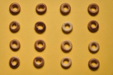 Sarı yüzeydeki Sushki deseninin üst görüntüsü. Rus ve Ukrayna mutfağından yemekler, hamur şeklinde katı halka şeklinde ürünler, koyun eti ürünleri. Slavlar arasında en yaygın çay atıştırmalıklarından biri.