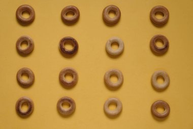 Sarı yüzeydeki Sushki deseninin üst görüntüsü. Rus ve Ukrayna mutfağından yemekler, hamur şeklinde katı halka şeklinde ürünler, koyun eti ürünleri. Slavlar arasında en yaygın çay atıştırmalıklarından biri.