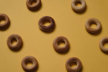 Sarı yüzeydeki Sushki deseninin üst görüntüsü. Rus ve Ukrayna mutfağından yemekler, hamur şeklinde katı halka şeklinde ürünler, koyun eti ürünleri. Slavlar arasında en yaygın çay atıştırmalıklarından biri.