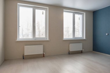 Mavi ve bej bir oda ve yeni evde iki pencere. Gayrimenkul kavramı. Pencereden yansıyan güneş ışığı.