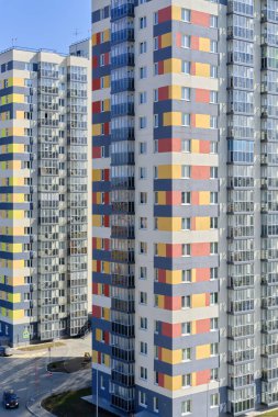 Facade of typical modern multi-storey building and vibrant blue sky as background. Residential complex called Green. Copy space image.
