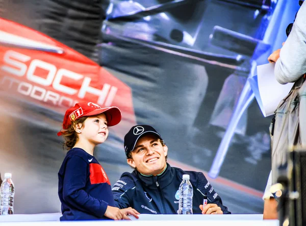 El autógrafo de cessie. Nico Rosberg con un joven admirador . — Foto de Stock