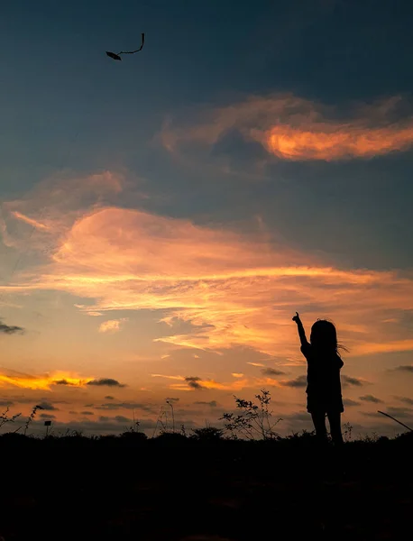 Silhouette Eines Mädchens Das Einen Drachen Fliegt — Stockfoto