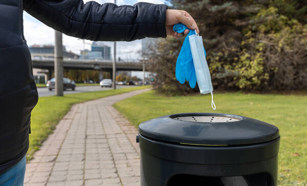 The used face mask and latex gloves are thrown into the trash can. Global outbreak of coronavirus. Global pandemic.