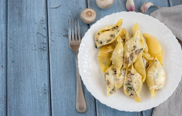 Pasta Conchiglioni Met Champignons Een Witte Plaat Houtondergrond — Stockfoto