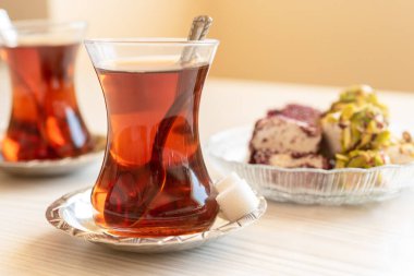 Geleneksel bir bardakta Türk çayı masanın üzerinde duruyor.