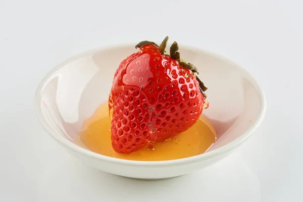 Strawberries with strawberry leaf and honey on a White background.